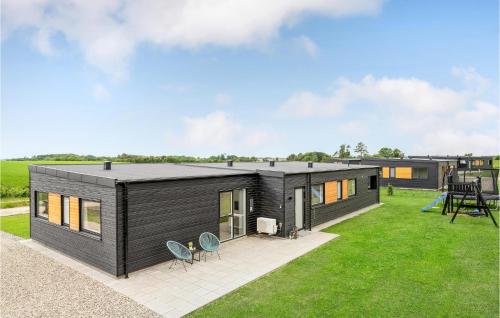 a black modular home with a patio and grass at Gorgeous Home In Løgstrup With Kitchen in Løgstrup