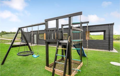 a house with a playground with a swing at Gorgeous Home In Løgstrup With Kitchen in Løgstrup