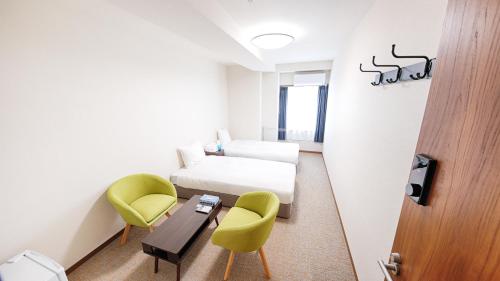 a room with a bed and two chairs and a table at Ayanishiki大阪西九条STAY in Osaka