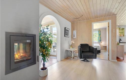 a living room with a fireplace and a chair at Awesome Home In Løgstør With Sauna in Trend
