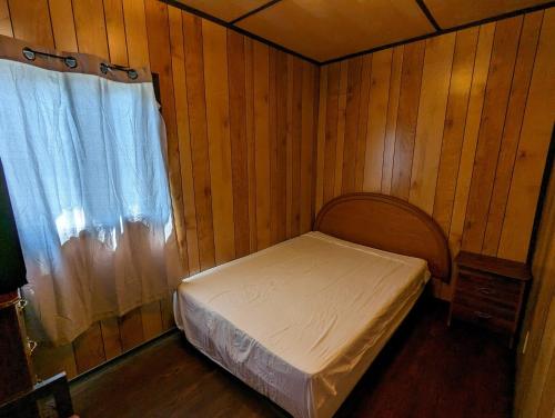 una piccola camera da letto con un letto e una finestra di Tiny Wood Cottage 06 a Wasaga Beach