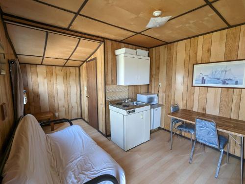 una piccola cucina in un rimorchio con tavolo e sedie di Tiny Wood Cottage 06 a Wasaga Beach