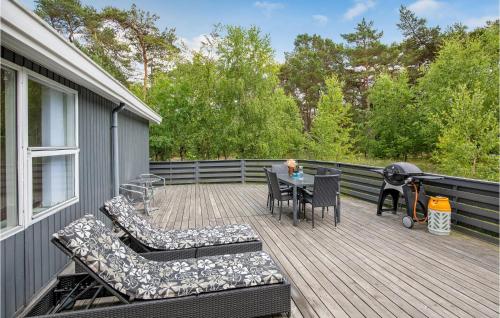 a deck with a table and chairs and a grill at Jægerstuen in Bedegård