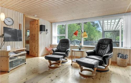 a living room with two chairs and a tv at Jægerstuen in Bedegård