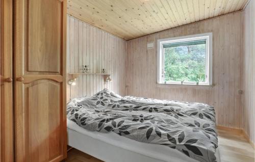 a bedroom with a bed with a black and white comforter at Jægerstuen in Bedegård