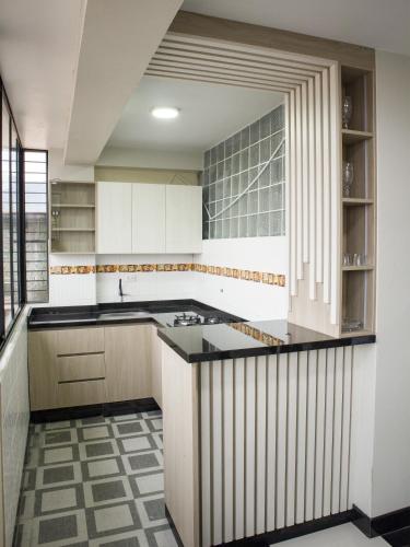 a kitchen with white cabinets and a black counter top at Resort Maldo in Ayacucho