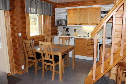 uma cozinha com uma mesa de madeira e cadeiras num camarote em Rinnetupa Apartment em Tahkovuori