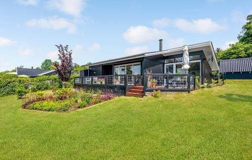 une maison avec une grande pelouse devant dans l'établissement Holiday Home Træløbervej Tranekær Ii, à Lokkeby