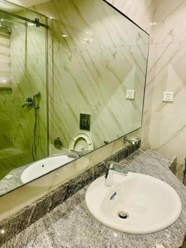 a bathroom with a sink and a large mirror at Luxury Oasis 2 - Entire 2 Bedroom Apartment in Abuja with Pool, Gym, WiFi, Balcony, and Garden in Abuja