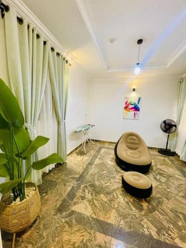 a living room with two ottomans and a plant at Luxury Oasis 2 - Entire 2 Bedroom Apartment in Abuja with Pool, Gym, WiFi, Balcony, and Garden in Abuja
