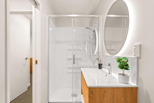 a bathroom with a sink and a mirror and a shower at Starlet 11 in Lake Tekapo