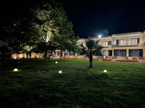 a building with a tree and some balls in the grass at Orb Inn in Sarandë