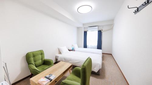 a room with a bed and a table and chairs at Ayanishiki大阪西九条STAY in Osaka