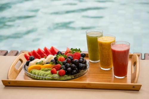 een schaal fruit op een tafel met twee drankjes bij GreenHousi Prea in Prea