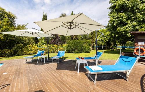 a patio with chairs and umbrellas and a pool at Villa Elena in Barbaricina