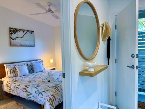 a bedroom with a bed and a mirror on the wall at Seaside Cottage in Curl Curl