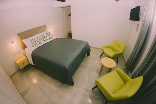 a bedroom with a green bed and two green chairs at Lu De Anda Hotel Boutique in San Luis Potosí