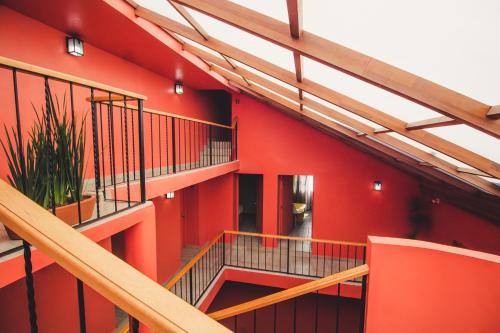 a building with red walls and wooden stairs at Lu De Anda Hotel Boutique in San Luis Potosí