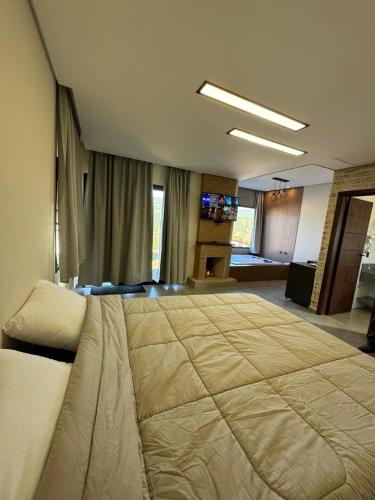 a bedroom with a large bed in a room at Chalés Varandas da Serra in Monte Verde