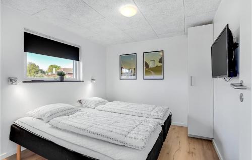 a white bedroom with a bed and a flat screen tv at Four-Bedroom Holiday Home In Haderslev in Haderslev