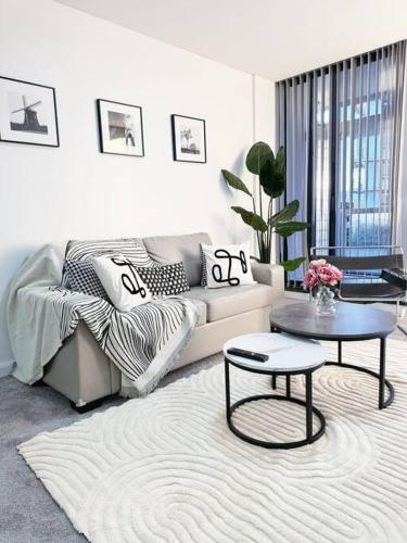 a living room with a couch and a table at Chic Modern Oasis - Steps from Darling Harbour in Sydney