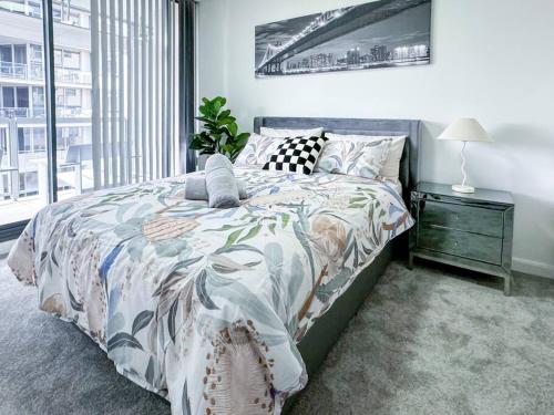 a bedroom with a bed with a large window at Chic Modern Oasis - Steps from Darling Harbour in Sydney