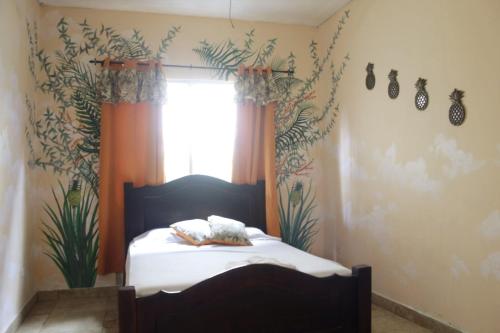a bedroom with a bed and a window with plants at Cataleya Hostel in Bocas del Toro
