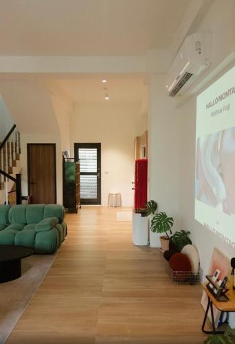a living room with a green couch and a slide at 無處 Nowhere Retreat 獨棟空間 in Yilan City