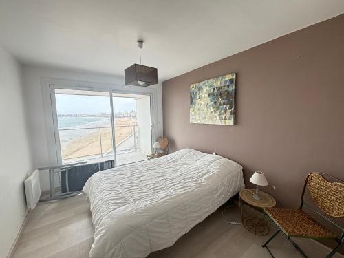 une chambre avec un lit et une grande fenêtre dans l'établissement Appartement 2 étoiles avec balcon-terrasse, 1 chambre, parking, près de la mer - FR-1-197-491, à Les Sables-dʼOlonne