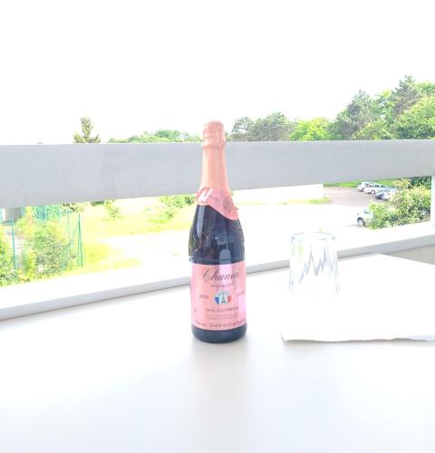 - une bouteille de vin assise sur une table à côté d'une fenêtre dans l'établissement Beautiful decorated Classy Appartment, Évry-Courcouronnes