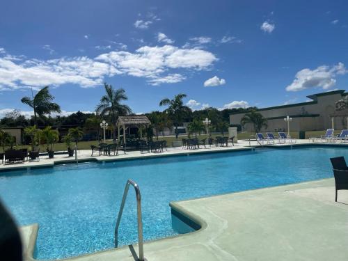 a swimming pool with chairs and tables in a resort at Princess Vegas Hotel & Casino in Corozal