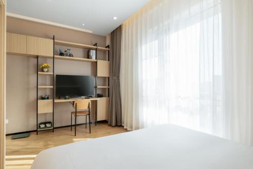 Una televisión o centro de entretenimiento en Nost algia S Hotel Beijing Liangxiang University Town 时光漫步S酒店北京良乡大学城广阳城地铁站店 Free fresh ground coffee,Free laundry service