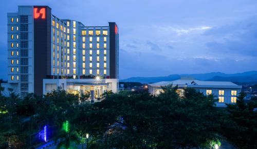 バンダールランプンにあるSwiss-Belhotel Lampungの夜の街で明かりが灯っている高層ビル