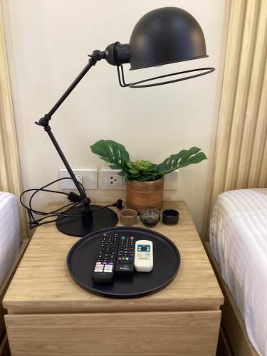 a desk with a lamp and remote controls on it at D' Residences in Cebu City