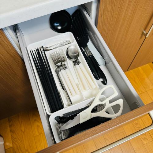 a drawer filled with utensils in a cabinet at Thanyaporn Hotel in Takayama
