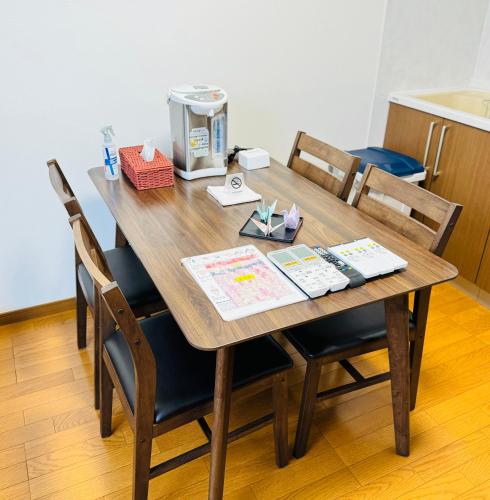 a wooden table with chairs and a coffee maker on it at Thanyaporn Hotel in Takayama
