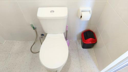 ein weißes WC im Bad mit einer Rolle Toilettenpapier in der Unterkunft Libertad Gate 1 in Ormoc City