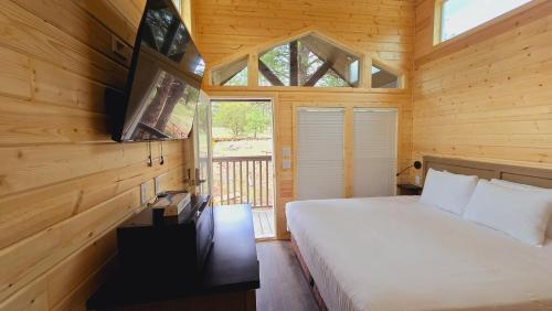 a bedroom with a bed in a wooden cabin at Cozy Cabins By Forest View 3B in Williams