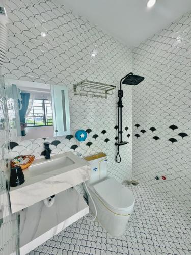 a white bathroom with a toilet and a sink at Sky Star 3 Hotel in Can Tho
