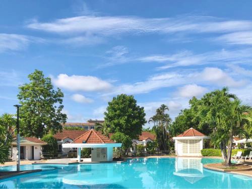 a large swimming pool at a resort with trees at Dad D Resort by Lopburi Inn Resort in Lop Buri