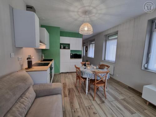 un salon avec une table et une cuisine dans l'établissement Charmante Maison 50 m² avec Terrasse et Parking - Tout Inclus, Proche Cambrai et Activités Nautiques - FR-1-510-202, à Iwuy