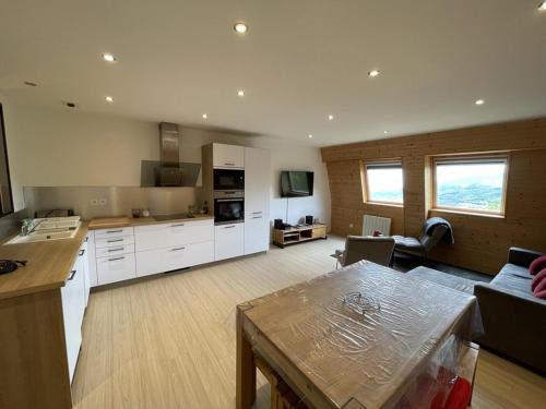 une grande cuisine avec des placards blancs et un salon dans l'établissement Appartement T3 confortable avec 2 chambres, parking, proche pistes - FR-1-787-1, à Saint-Jacques-des-Blats