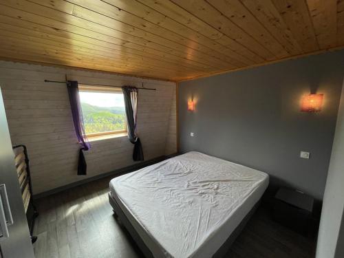 a bed in a small room with a window at Beau duplex 6 pers. à 200m des pistes, parking gratuit - FR-1-787-11 in Saint-Jacques-des-Blats