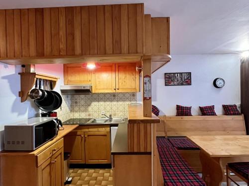 une cuisine avec des armoires en bois et un comptoir dans l'établissement Charmant studio au coeur de la station, balçon exposé, idéal pour 4 personnes - FR-1-787-7, à Laveissière