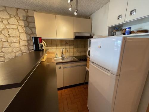 une cuisine avec un réfrigérateur blanc et un évier dans l'établissement Studio agréable avec balcon SE, proximité pistes et commerces, 2é étage, animaux acceptés - FR-1-787-27, à Laveissière