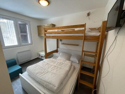 - une chambre avec 2 lits superposés et une télévision dans l'établissement Appartement T2 cabine avec balcon, face aux pistes, exposé sud, commerces à proximité - FR-1-787-29, à Laveissière