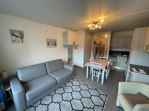 un salon avec un canapé et une table dans l'établissement Charmant Studio au Coeur de la Station avec Terrasse ensoleillée et Proximité Commerces et Pistes - FR-1-787-30, à Laveissière