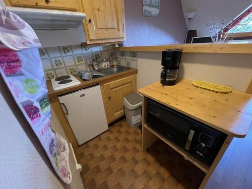 une petite cuisine avec un évier et un micro-ondes dans l'établissement Charmant T2 cabine au pied des pistes - 4 pers - FR-1-787-32, à Laveissière