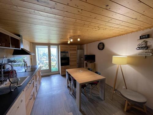 une cuisine avec un plafond en bois et une table en bois dans l'établissement Chaleureux duplex avec balcon près des pistes - FR-1-787-16, à Saint-Jacques-des-Blats
