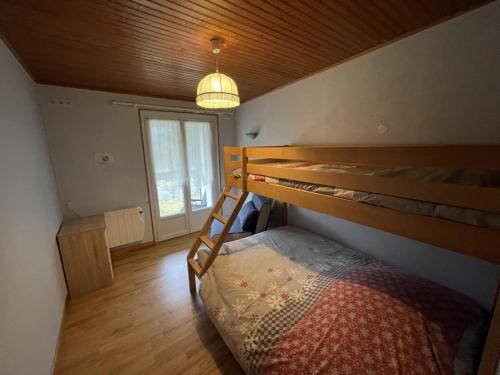 ein Schlafzimmer mit Etagenbett und Fenster in der Unterkunft Grand chalet mitoyen dans secteur calme et ensoleillé - FR-1-787-38 in Laveissière